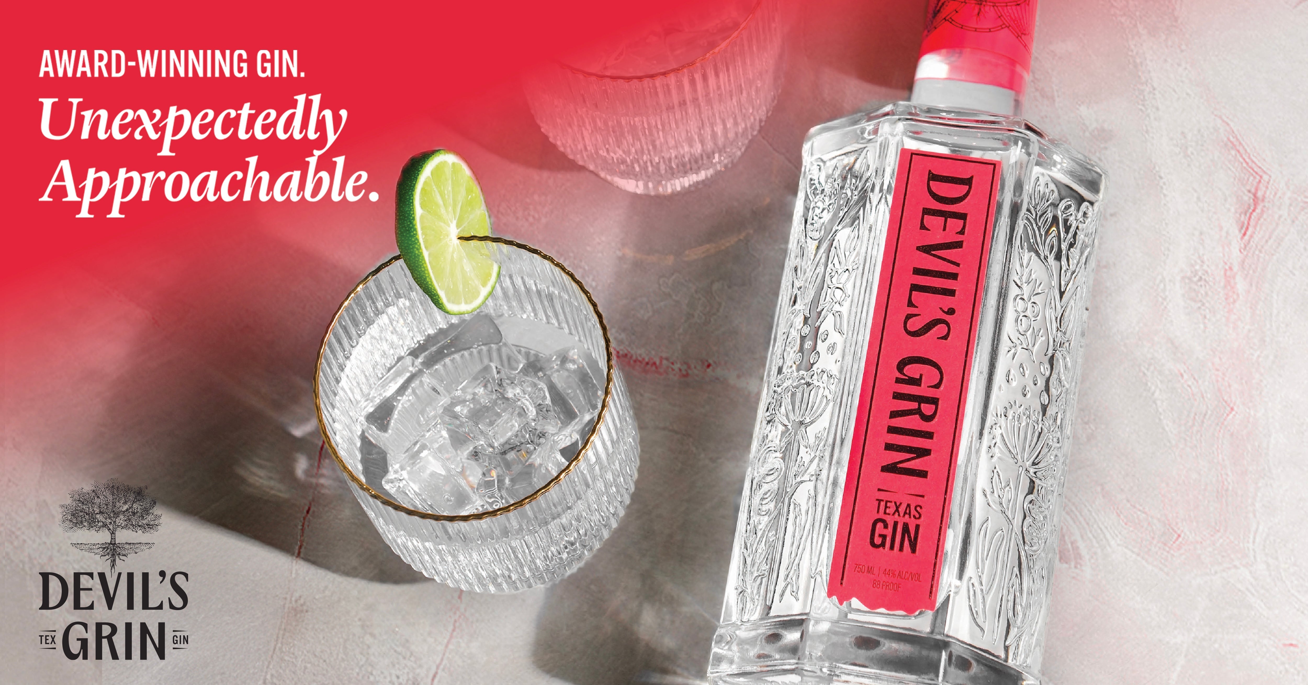 Devil's Grin award-winning Texas Gin bottle with lime gimlet cocktail in gold-rimmed rocks glass