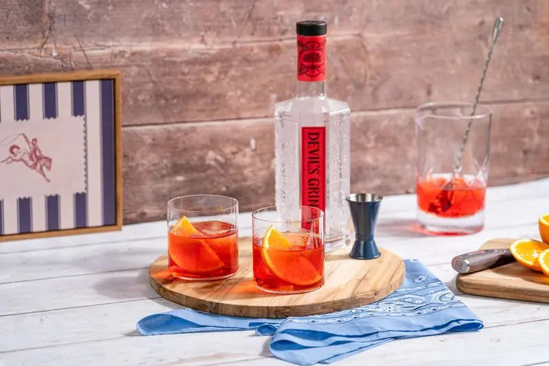 Devil&rsquo;s Grin bottle and two negronis on a bar